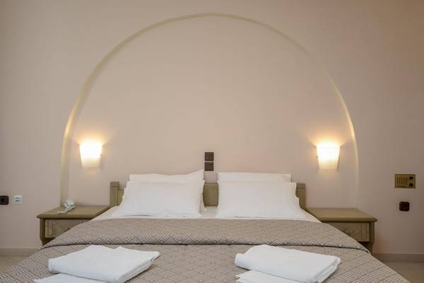 Schlafzimmer im Proteas Hotel & Suites mit einem Doppelbett und weißen Laken.