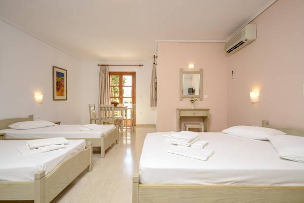 Drei Betten im Schlafzimmer des Proteas Hotel & Suites mit weißen Laken und Kissen.