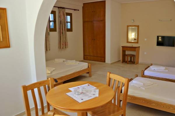 Ein Schlafzimmer im Proteas Hotel mit zwei Betten, Kleiderschrank, Tisch, Fernseher und Spiegel.