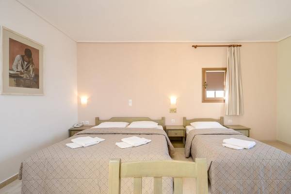 Doppelzimmer im Proteas Hotel & Suites mit zwei Betten, Nachttischen und Fenstern.