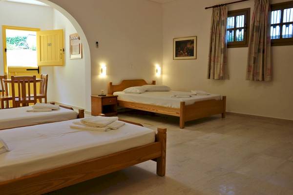 Proteas Hotel & Suites Schlafzimmer mit drei Betten und einem kleinen Esstisch.