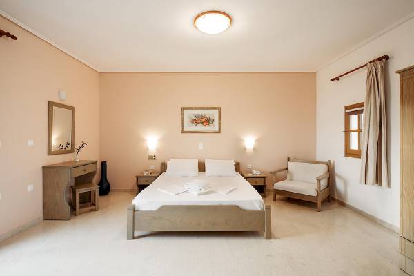 Ein elegantes Schlafzimmer im Proteas Hotel & Suites mit einem Doppelbett, Nachttischen, einem Spiegel und einer Fensterbank.