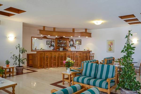 Barbereich des Proteas Hotel & Suites mit Holztheke und blau-grün gestreiften Stühlen.