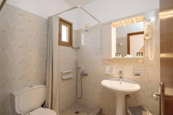 Badezimmer im Proteas Hotel & Suites mit Dusche, Toilette und Waschbecken.