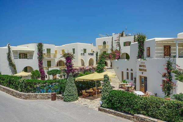 Außenansicht des Proteas Hotel & Suites mit Swimmingpool und Terrassenmöbeln.
