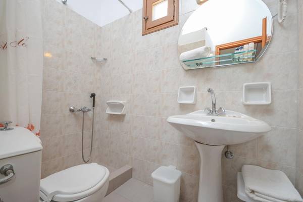 Badezimmer im Proteas Hotel mit Toilette, Waschbecken und Dusche.