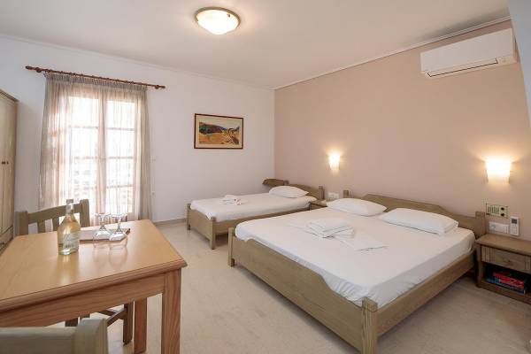 Doppelbettzimmer im Proteas Hotel mit zwei Betten, Tisch, Stühlen und Klimaanlage.