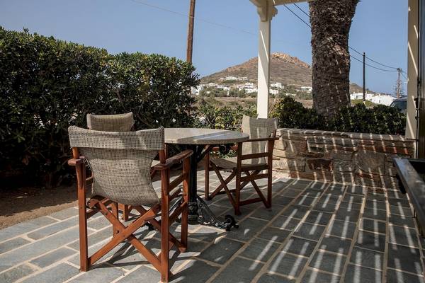 Terrasse des Proteas Hotel & Suites mit Tischen und Stühlen.
