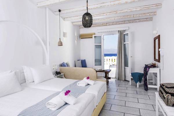 Doppelzimmer mit Meerblick im Cycladic Islands Hotel & Spa mit geräumigem Bett, Sofa, Balkon und Meeraussicht.