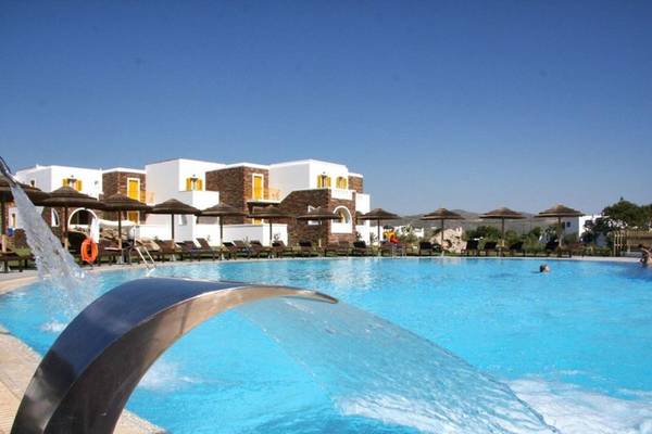 Außenbereich des Pools im Aegean Palace Hotel mit Wasserfontäne und Sonnenschirmen.