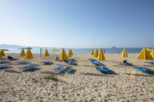 Strand des Mikri Vigla Hotels mit gelben Sonnenschirmen und Liegen am Meer