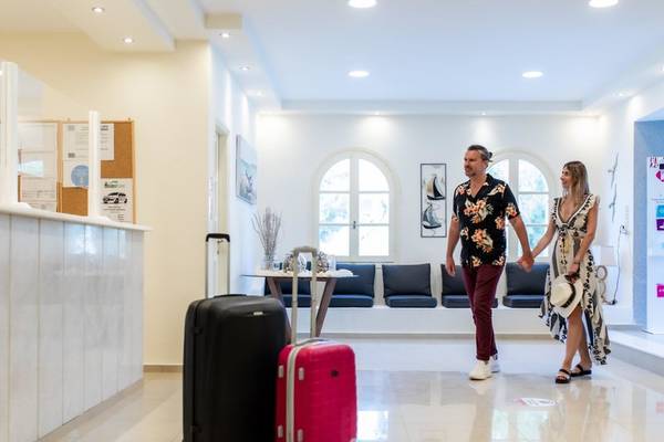 Ein Paar geht im Eingangsbereich des Mikri Vigla Hotels mit Gepäck