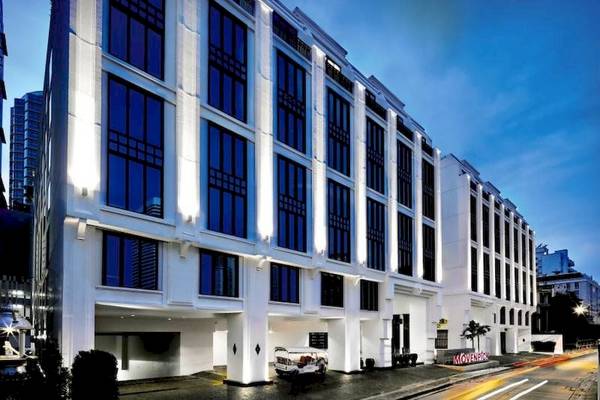 Außenansicht des Mövenpick Hotels Sukhumvit 15 in Bangkok mit vielen Fenstern und einer offenen Einfahrt.
