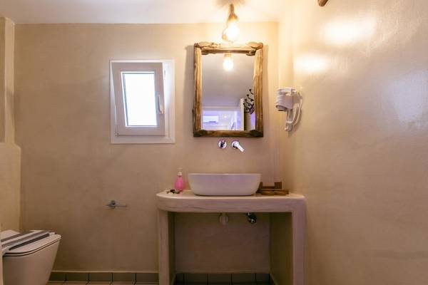 Badezimmer im Mikri Vigla Hotel mit weißem Waschbecken und Spiegel