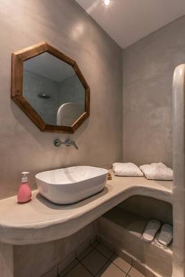 Das Badezimmer im Mikri Vigla Hotel mit einer Badewanne, Waschbecken und Handtüchern.
