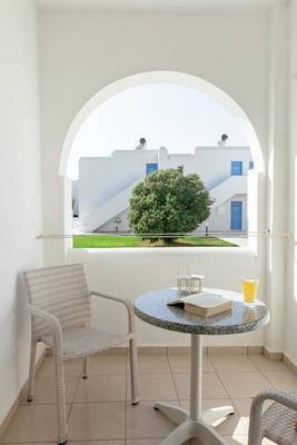 Mikri Vigla Hotel Balkon Sitzecke mit Tisch und Büchern.