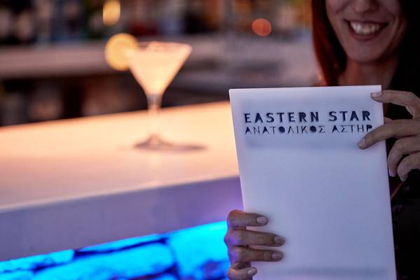 Frau die eine Eastern Star Karte bei einem Cocktail hält.