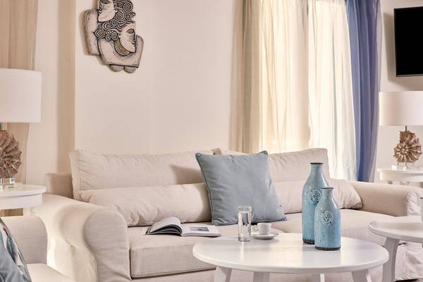 Wohnzimmer im Lagos Mare Hotel mit Couch, Tischen und Dekorelementen.