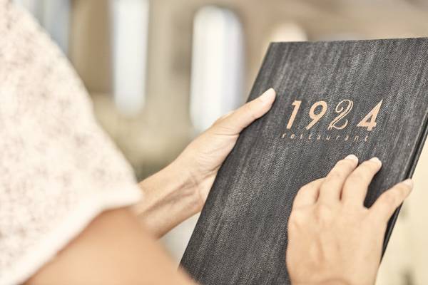 Frau hält ein Buch des 1924 Restaurants in den Händen.