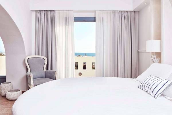 Schlafzimmer im Lagos Mare Hotel mit Blick auf das Meer und einem großen Bett.
