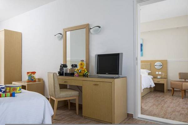 Innenansicht eines Zimmers im Lagos Mare Hotel mit Bett, Schreibtisch und Fernseher.