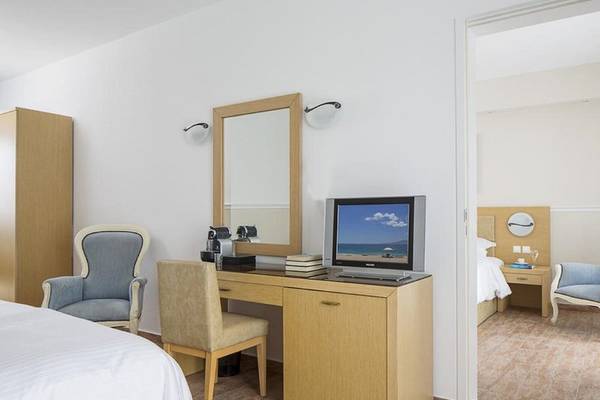 Hotelzimmer im Lagos Mare mit Schreibtisch, Fernseher, Spiegel und Möbeln.