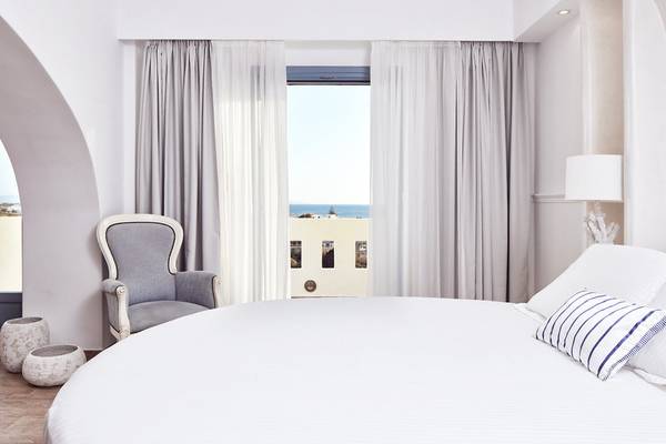 Schlafzimmer im Lagos Mare Hotel mit Blick auf das Meer und eine Veranda.