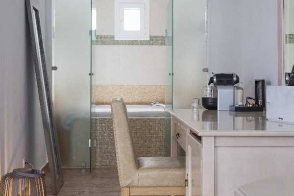 Innenansicht eines Badezimmers im Lagos Mare Hotel mit Badewanne und Schreibtisch.