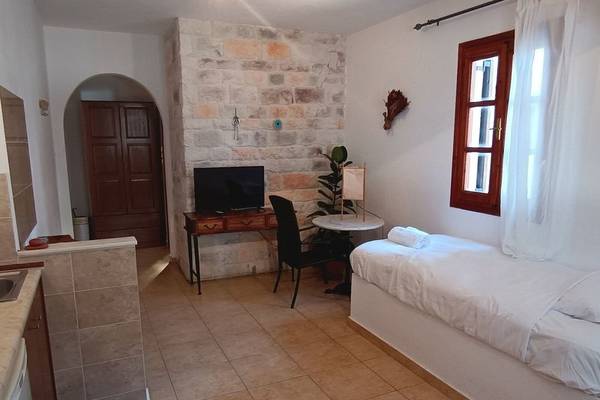Ein modernes Hotelzimmer mit Bett, Fernseher, Tisch und Stühlen im Naxos Summerland Resort.