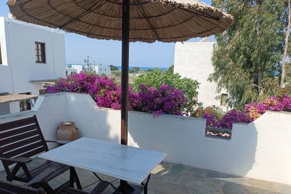 Terrasse mit Tisch und Schirm im Naxos Summerland Resort Hotel