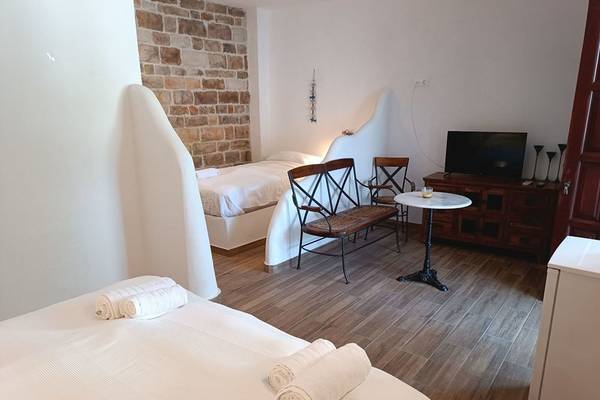Schlafzimmer im Naxos Summerland Resort mit zwei Betten, Möbeln und Fernseher.