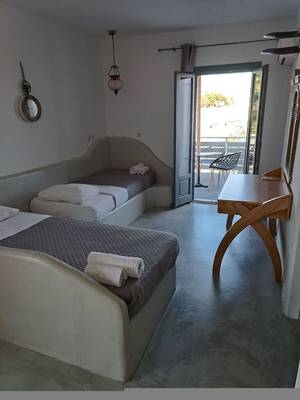 Schlafzimmer mit zwei Betten und Balkon im Naxos Summerland Resort.