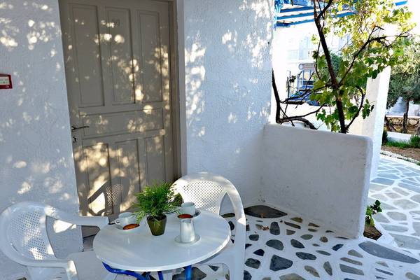 Terrasse des Amaryllis Paros Beach Hotels mit weißem Tisch und Stühlen.