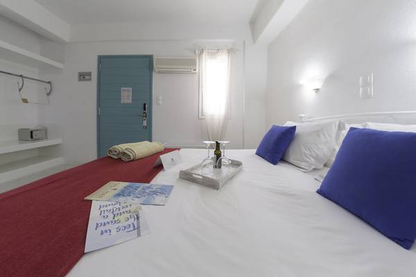 Schlafzimmer im Amaryllis Paros Beach Hotel mit einem Bett, zwei Kissen und einem Nachttisch