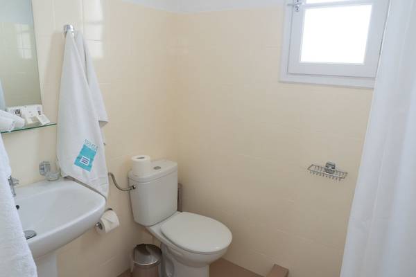 Badezimmer im Amaryllis Paros Beach Hotel mit Toilette, Waschbecken und Spiegel.