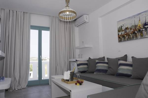 Innenraum des Amaryllis Paros Beach Hotel mit modernem Design, Sofa, Tisch, und Fenster.