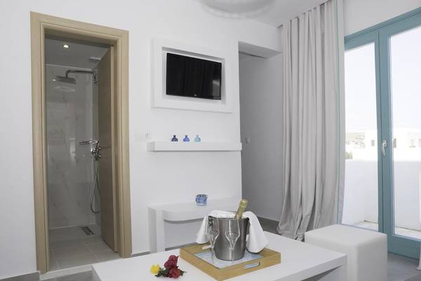 Innenansicht eines Zimmers im Amaryllis Paros Beach Hotel mit Dusche, Fernseher und Balkon