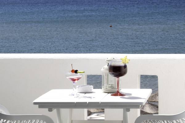 Auf der Terrasse des Amaryllis Paros Beach Hotels mit zwei Cocktails und einem Blick auf das Meer.