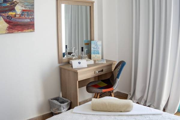 Hotelzimmer im Amaryllis Paros Beach Hotel mit Bett, Schreibtisch und Spiegel.