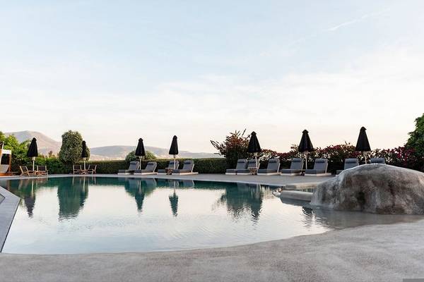 Poolbereich des Paros Agnanti Resort & Spa mit Liegestühlen und Sonnenschirmen