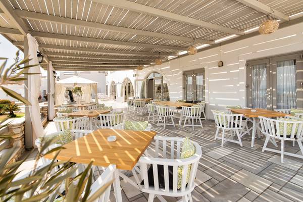 Terrasse im Paros Agnanti Resort & Spa mit Tischen und Stühlen