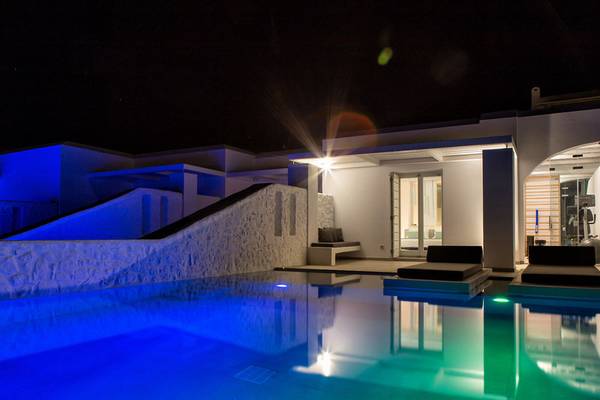Nachtansicht des Paros Agnanti Resorts und Spa mit beleuchtetem Pool.
