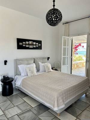 Schlafzimmer im Paros Agnanti Resort & Spa mit Blick auf das Meer.