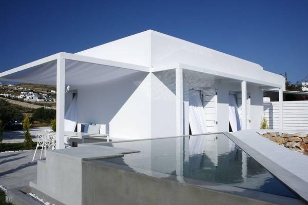 Außenbereich des Paros Agnanti Resort & Spa mit Swimmingpool und weißen Möbeln