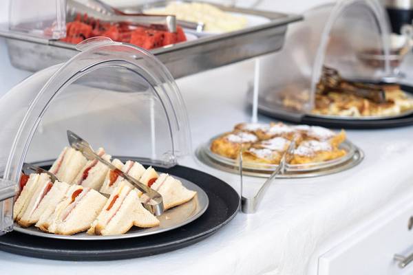 Frühstücksbuffet im Iris Boutique Hotel mit Sandwiches, Früchten und Waffeln.