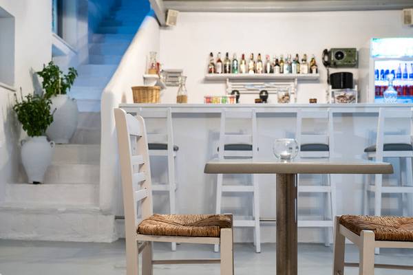 Innenansicht des Iris Boutique Hotels mit Bar, Tisch und Stühlen.