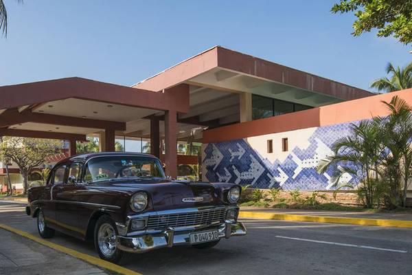 Chevrolet vor dem Gran Caribe Villa Tortuga Hotel mit blauen Mustern an der Wand