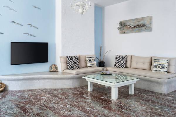 Wohnzimmer im Iris Boutique Hotel mit blauen Wänden, weißen Möbeln, Fernseher und Couch