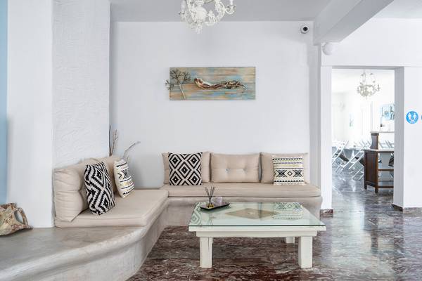 Innenbereich des Iris Boutique Hotel mit einer Couch, einem Glastisch und einem Gemälde an der Wand.
