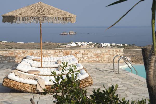 Terrasse des Mythic Hotels mit Blick auf das Meer, umgeben von einer Steinmauer.